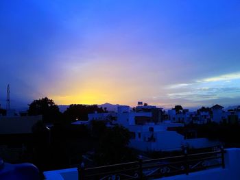 High angle view of silhouette buildings against sky at sunset