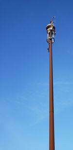 Low angle view of communications tower against blue sky