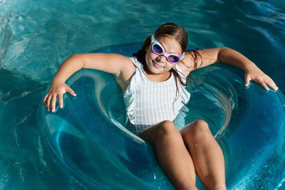  girl swimming on a floaty in the pool
