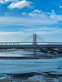 Bridge over sea against sky during winter