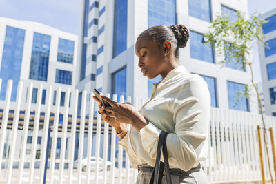 Female entrepreneur using mobile phone in city