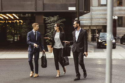 Male and female entrepreneurs discussing business strategy while walking outdoors