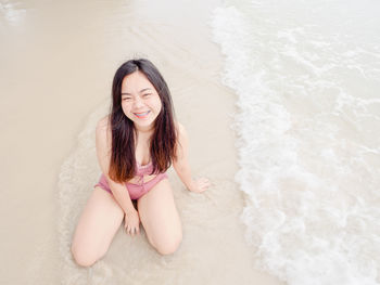 Portrait of young woman standing at beach