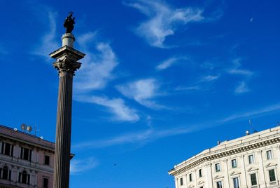 Low angle view of column and building against blue sky