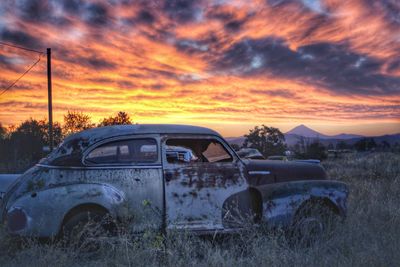 Cars parked on field at sunset