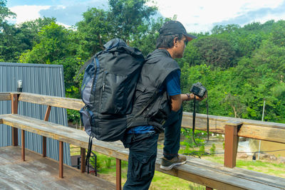 Young photographer holding digital camera standing on resort lifestyle concept