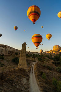 Hot air balloons flying over landscape against sky