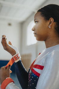 Teenage girl wearing protection band while standing in gym