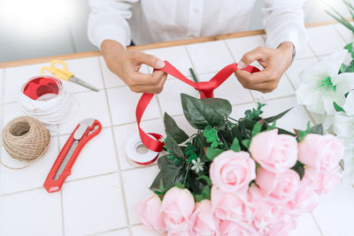 Midsection of woman making bouquet in flower shop