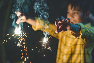 View of a woman with fire crackers at night