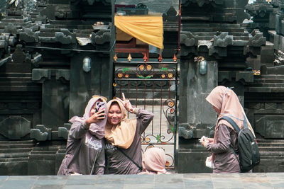 Woman with umbrella sitting outside building