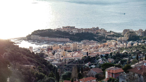 High angle view of townscape by sea against sky