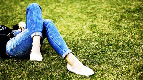 Low section of woman standing on grassy field