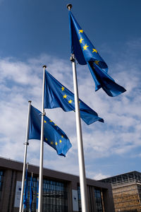 Low angle view of flags against blue sky