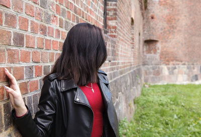 Full length of woman standing against wall