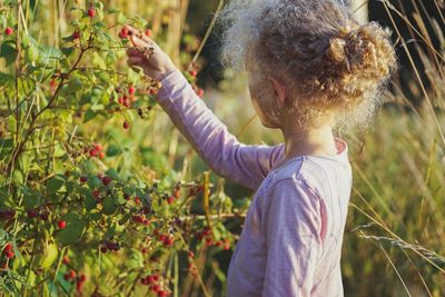 Girl touching berries fruits on plant