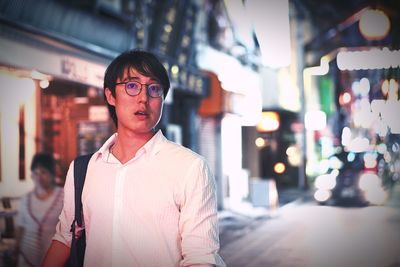 Portrait of mid adult man standing in illuminated room