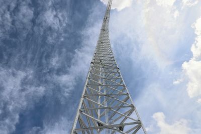 Low angle view of communications tower against sky