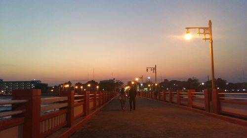 Illuminated street light against sky at night