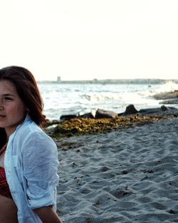 Woman on beach against clear sky