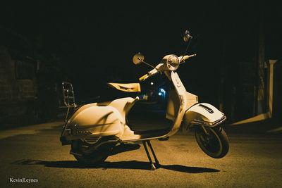 Motor scooter parked on road at night
