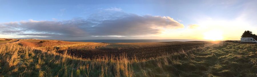 Scenic view of land against sky during sunset