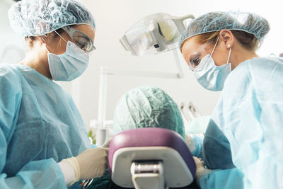 Dentists examining woman at clinic