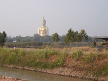 Statue on field against sky