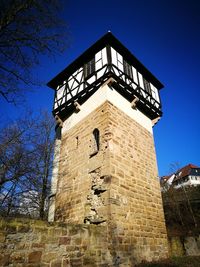 Low angle view of clock tower against clear blue sky