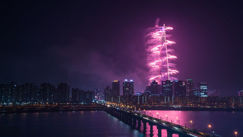 Low angle view of firework display in city at night