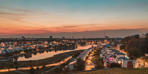 High angle view of illuminated buildings against sky at sunset