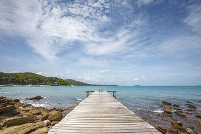 Wide angle shot of dock to the sea with bright blue sky and cloud in relax summer day