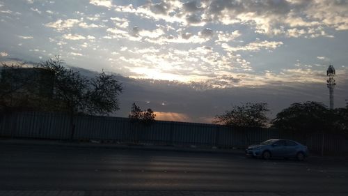 Car on road against sky at sunset