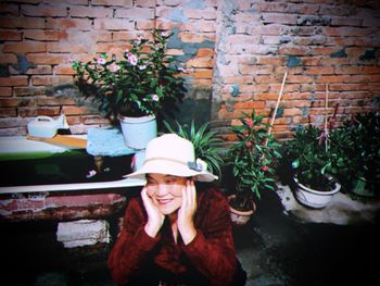 Portrait of a smiling young woman with potted plants