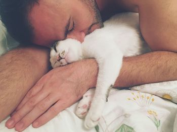 Close-up of cat sleeping on bed