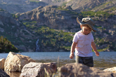 Full length of cute boy standing on rock