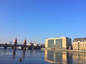 Buildings in city against clear blue sky