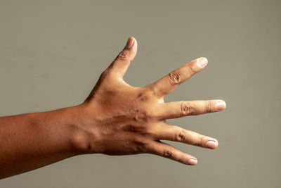 Close-up of hand against gray background