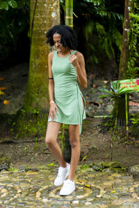 Girl in a green dress and white sneakers at a park.