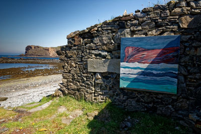 View of flag on beach against blue sky