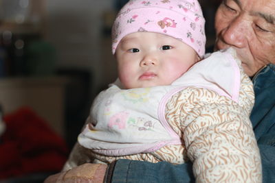 Portrait of cute baby boy lying on bed at home