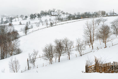 Scenic view of village on snowy hill in a winter day
