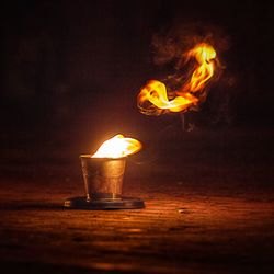 Close-up of lit candle in dark room
