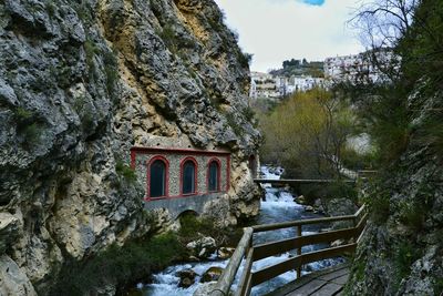 Built structure by river against sky