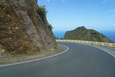 Empty road by mountain against sky