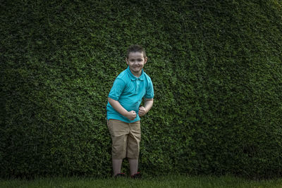 Portrait of boy standing against plants