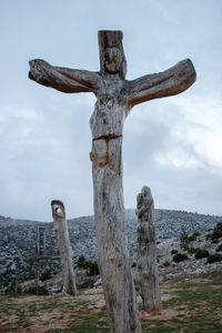 Cross on tree against sky