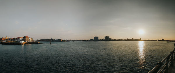 View of city at waterfront during sunset