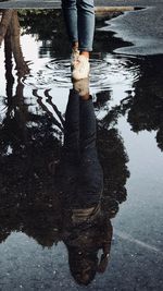 Low section of man standing in puddle