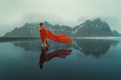 Lady wrapped with red fabric on reynisfjara beach scenic photography